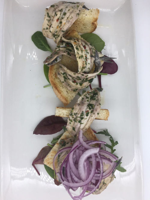 Alici nostrane marinate, su crostini dorati con cipolla rossa Alici nostrane marinate, su crostini dorati con cipolla rossa